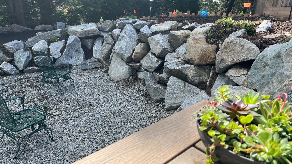 Finished boulder retaining wall and patio — Resident Rebuild project
