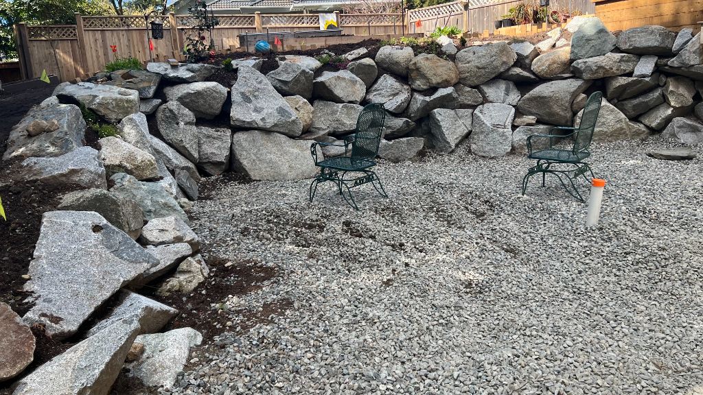 Finished boulder retaining wall with patio seating area